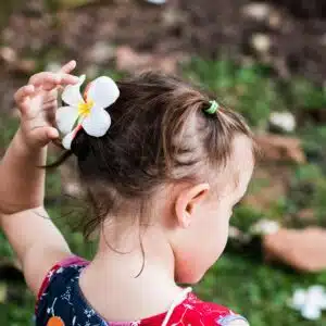 Petite fille avec une fleur glissée dans les cheveux